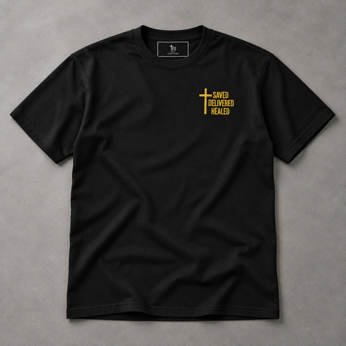 Black Saved Delivered Healed embroidered t-shirt, flat lay with Full Salvation woven neck label