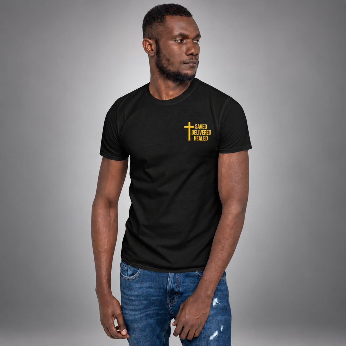 Man wearing a black Saved Delivered Healed embroidered cross t-shirt, front view