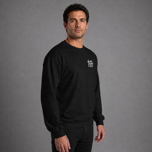 Full body side view of man wearing black Saved Delivered Healed embroidered crew neck sweatshirt
