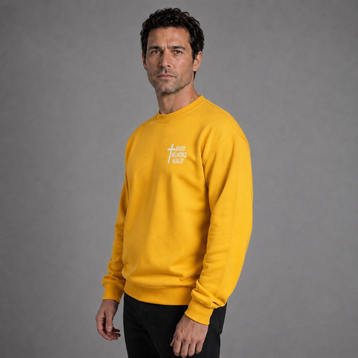 Man wearing gold Saved Delivered Healed embroidered crew neck sweatshirt