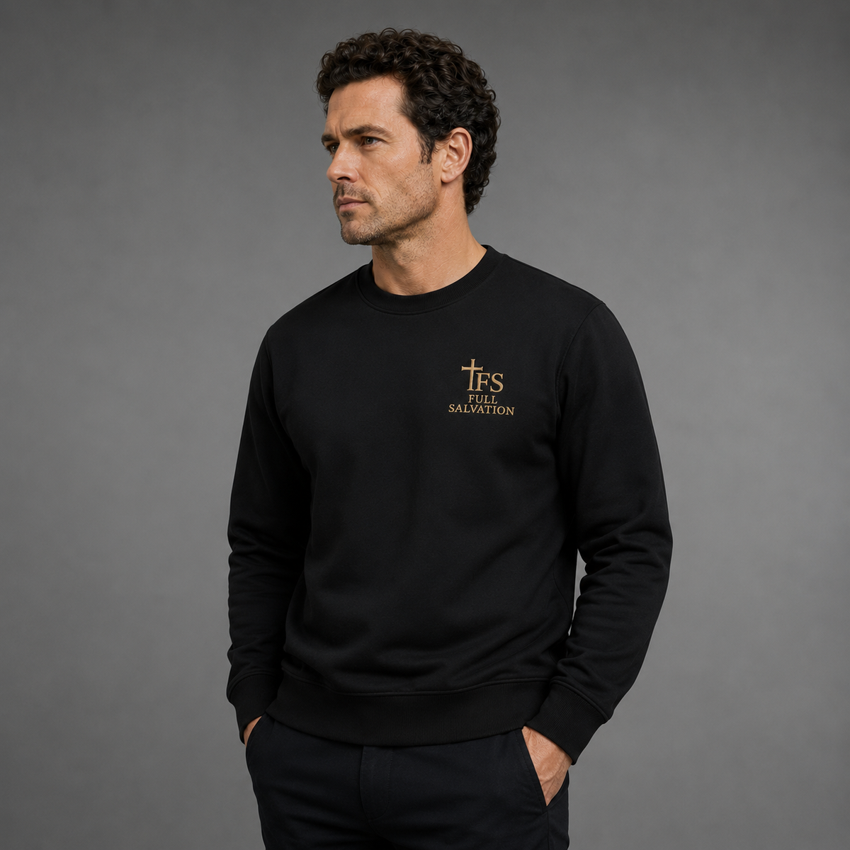Man wearing the Full Salvation Apparel Essential Organic Cotton Crewneck Sweatshirt in Black, three-quarter view with hands in pockets