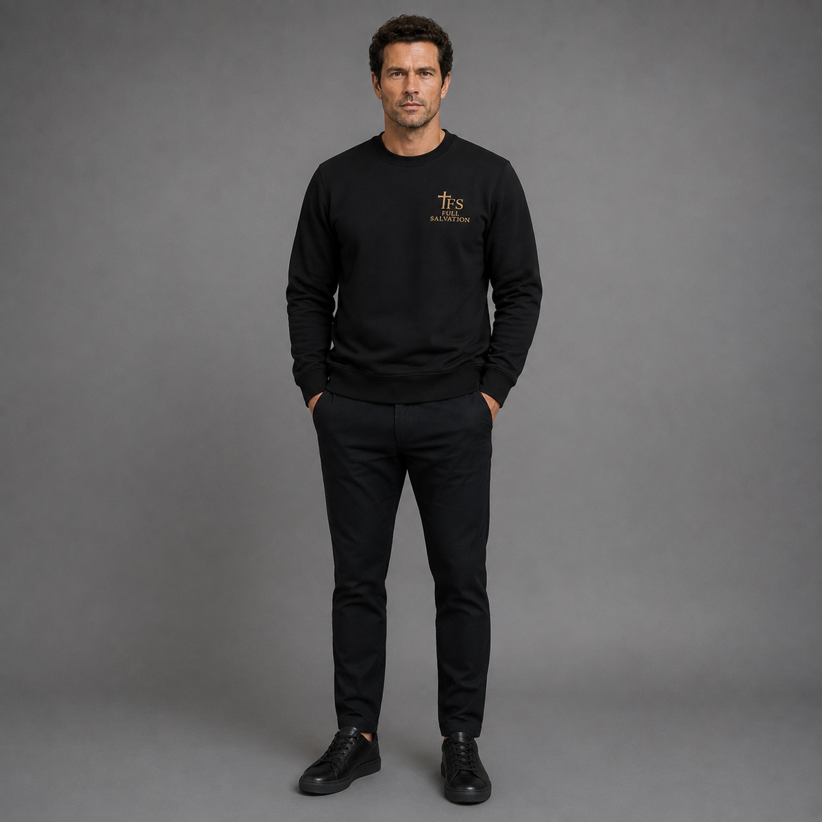 Full-length front view of a man wearing the Full Salvation Apparel Essential Organic Cotton Crewneck Sweatshirt in Black with black trousers and sneakers