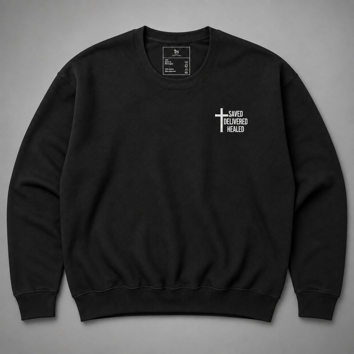 Black Saved Delivered Healed embroidered crew neck sweatshirt flat lay showing cross embroidery on the chest