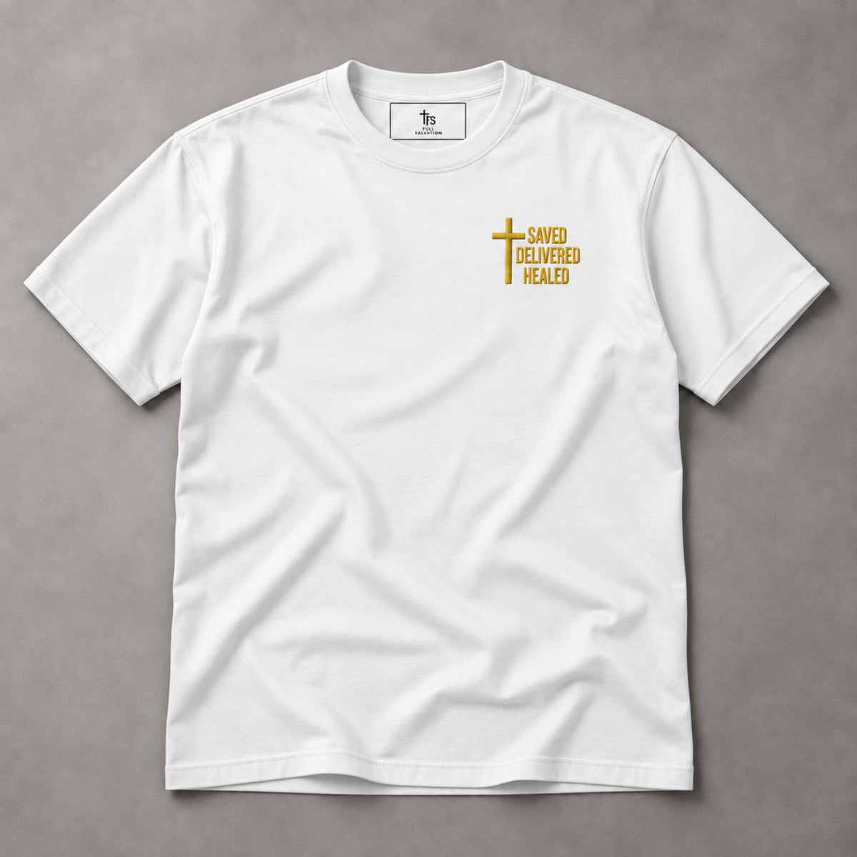 White Saved Delivered Healed embroidered t-shirt, flat lay with Full Salvation woven neck label